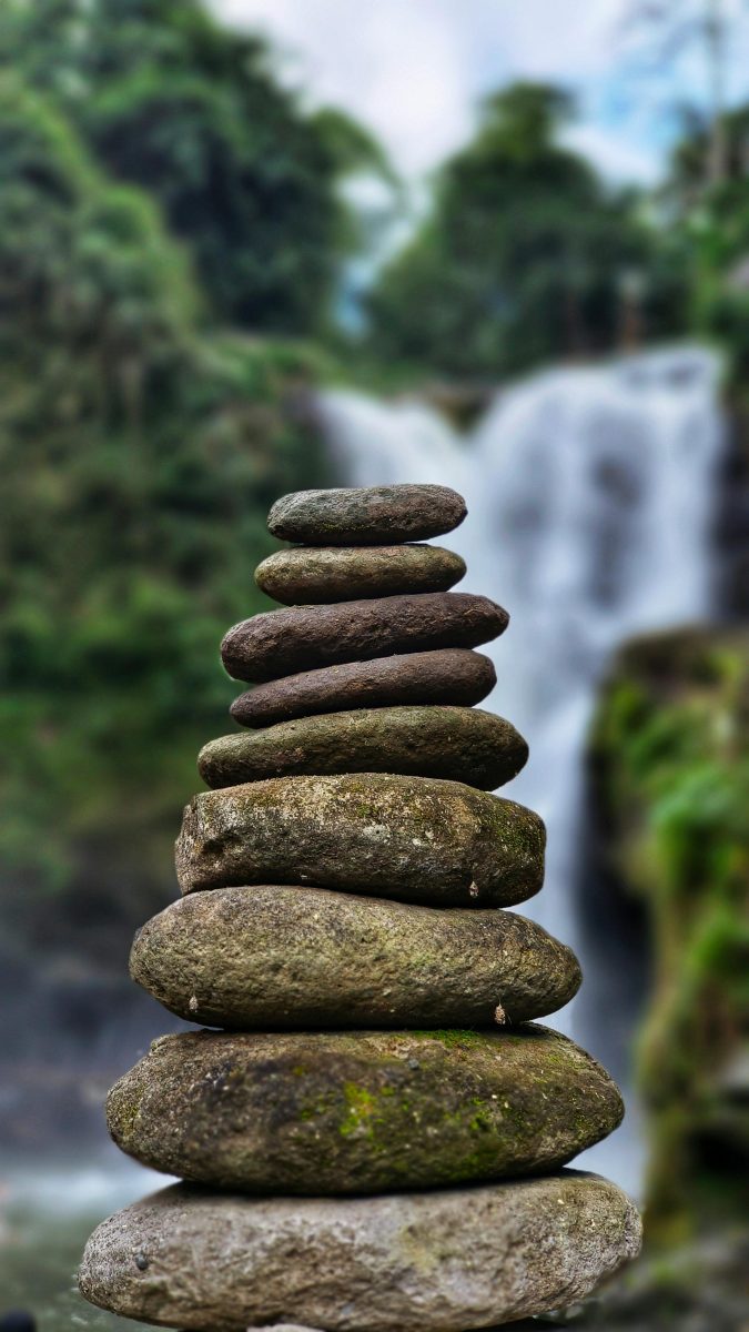 Columna de piedras en equilibrio junto a una cascada